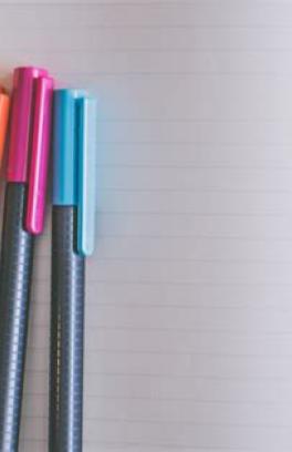A picture of 4 pens on a notebook.