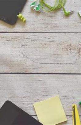 Preschool supplies such as paper, scissors, pencils as well as other craft materials laid out on a wood table.