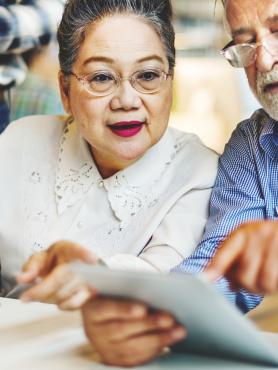 A senior helps a another with paperwork