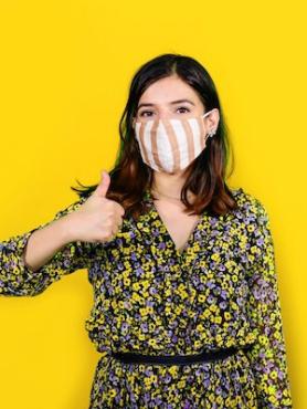 Student in a mask giving a thumbs up.
