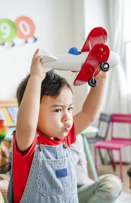 Child at daycare holding an airplane