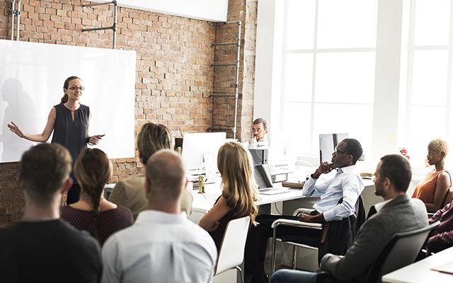 A room full of colleagues gather together for a workplace training.