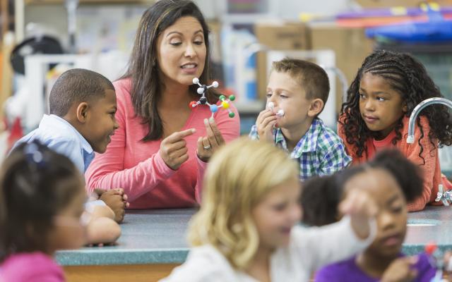 Science teacher in a classroom of children