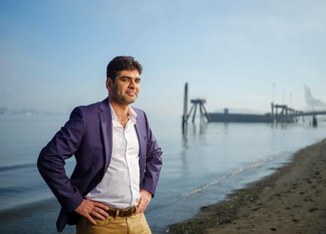 student on beach with pier in background