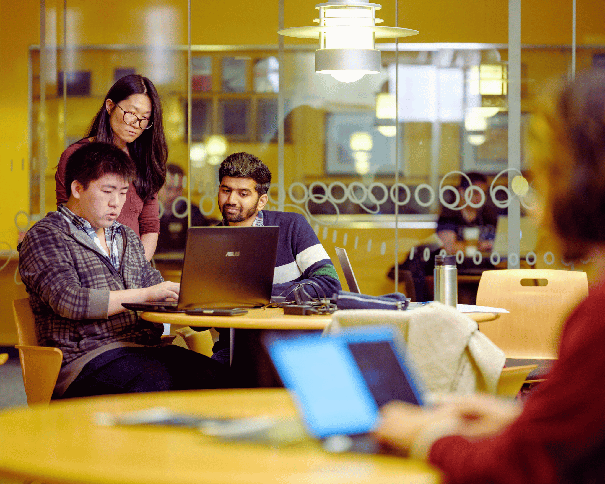 A group of students work together on a laptop. 