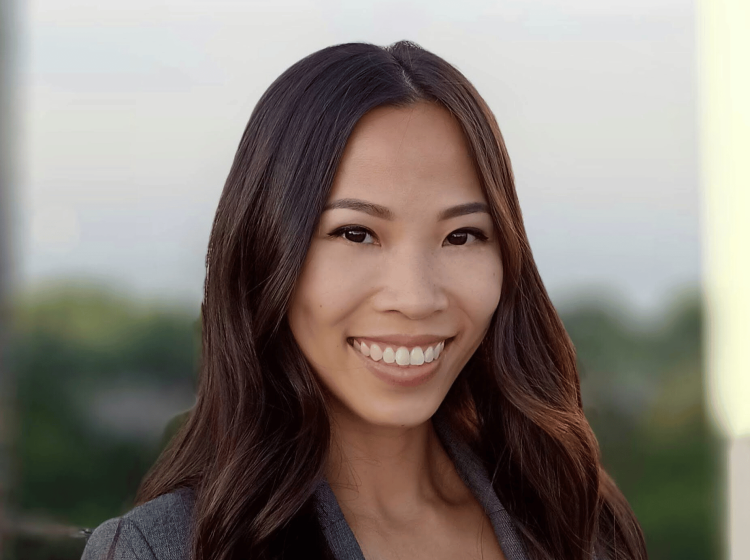 A professional headshot of a woman in a suit. 