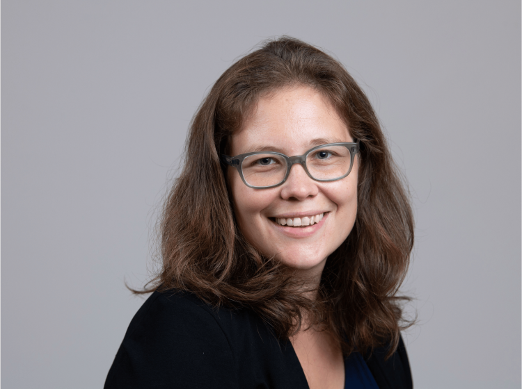 A headshot of a woman with glasses.
