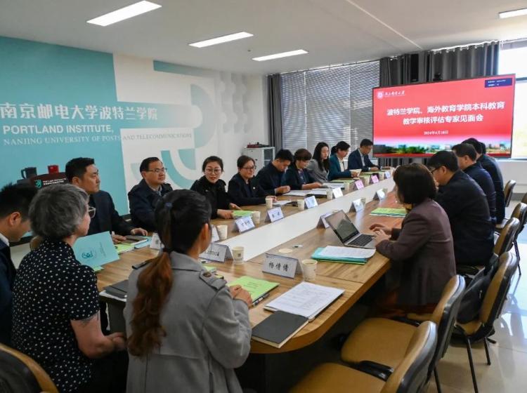 An academic meeting taking place at the Portland Institute, Nanjing University of Posts and Telecommunications. A group of professionals are seated around a long conference table in a modern room, with a digital screen and university branding visible in the background.