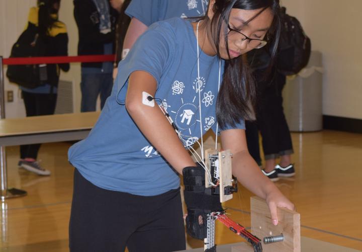 Student using robotic arm in competition