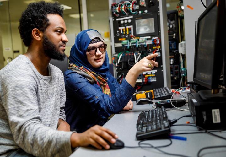 Two people working at a computer in a lab.