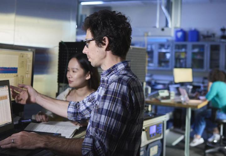 A picture of two people working on a computer.