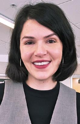 a woman with short dark hair smiles in an office