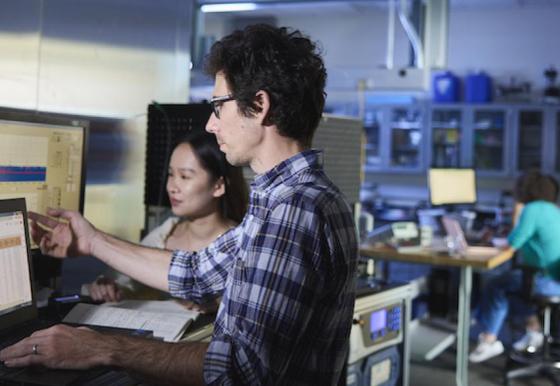 A picture of two people working on a computer.