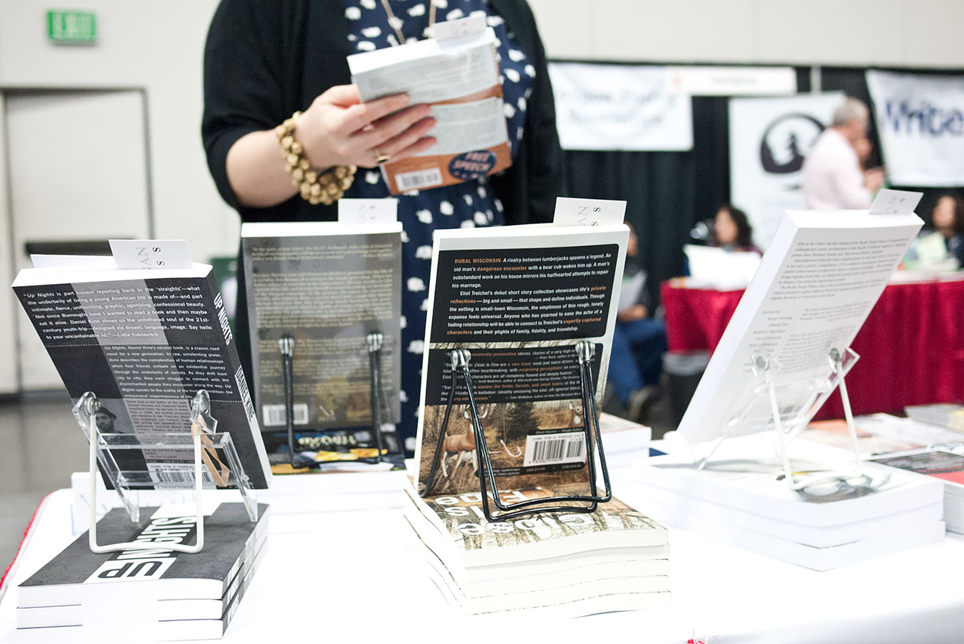 Books propped up at a booth, photographed from behind.