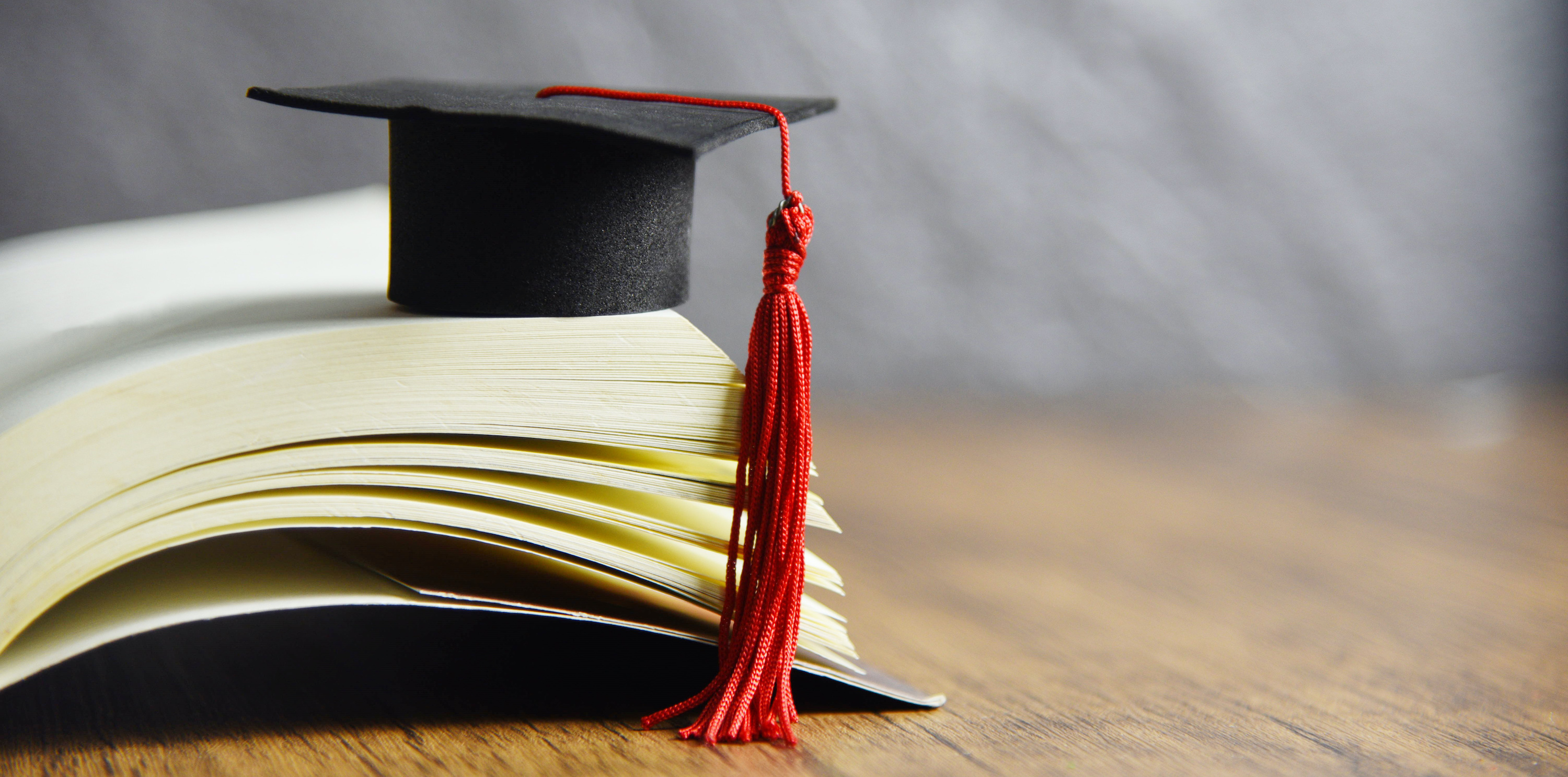 Graduation cap resting atop an open book