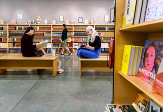 Two people sitting reading books