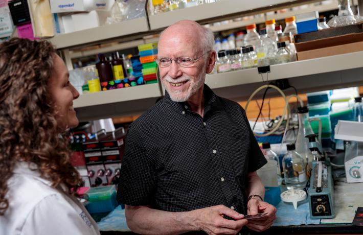 A student and faculty talk in a science lab environment