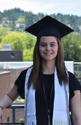 Student stands with graduation cap and EXITO stole