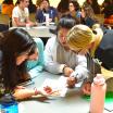 Students at a table look at a paper at new student orientation