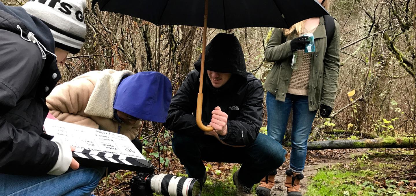 School of Film with umbrella and camera on trail