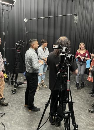 Group of students in film studion with microphone