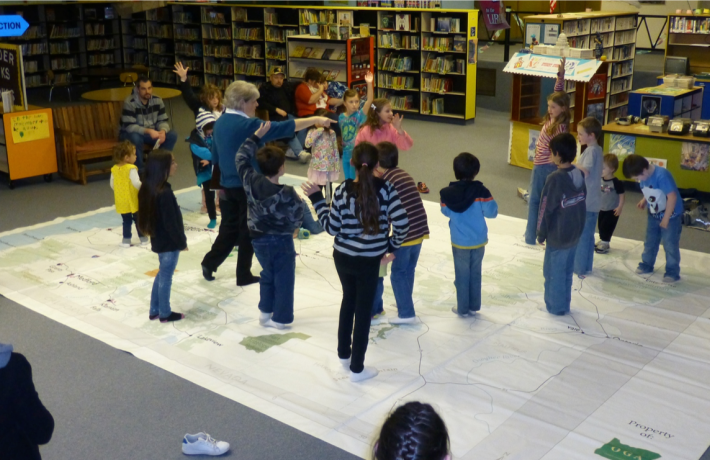 Teacher and children standing on the Giant Map of Oregon