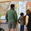 people looking at maps on the wall