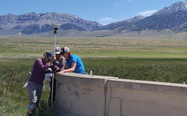 Grad students taking observations in field