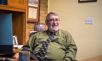 Dean Dave Bowman seated in his office