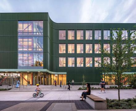 Exterior dusk view of the new Portland State University Jordan Schnitzer School of Art Building showing large illuminated windows and Douglas fir structural beams
