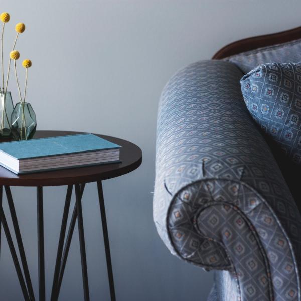 This photo is decorative. A blue chair and side table with a notebook.