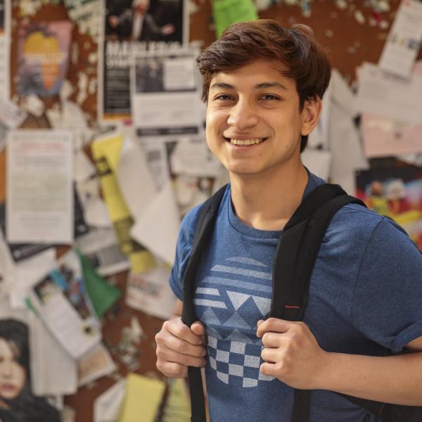 Smiling student outside of a classroom.