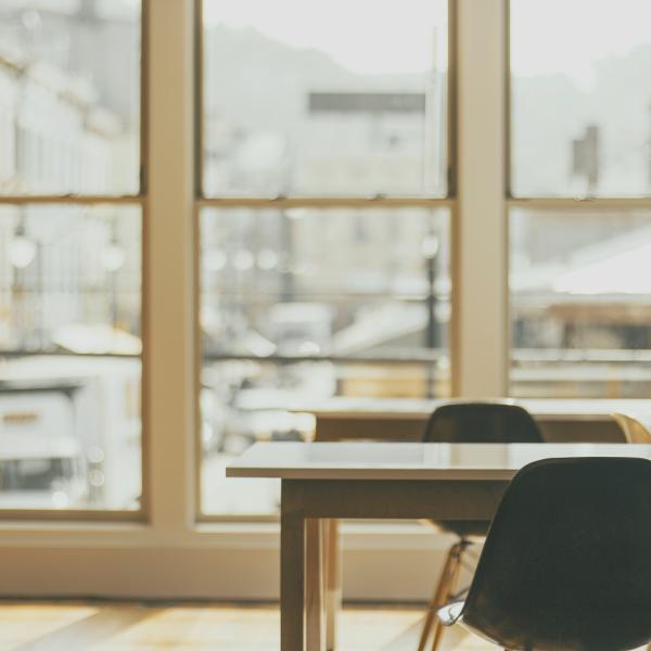 office view with two chairs, a desk and large glass windows