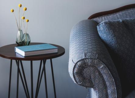 This photo is decorative. A blue chair and side table with a notebook.