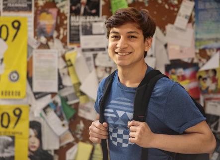 Smiling student outside of a classroom.