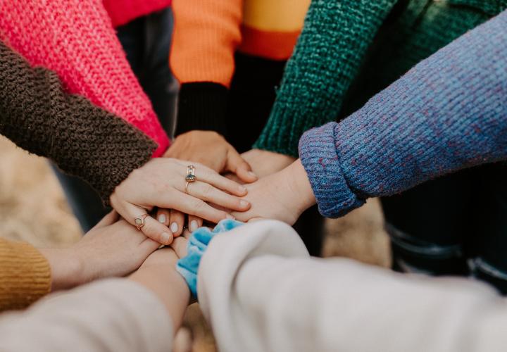 Hands in together supporting each other.