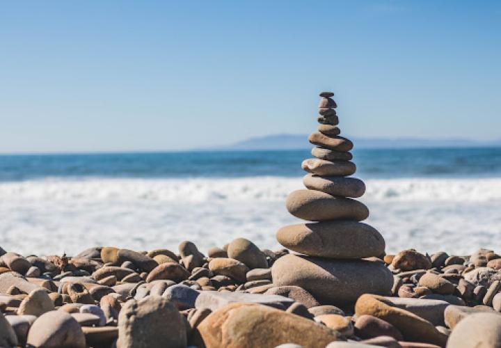 Pile of rocks next to the beach on a sunny day.