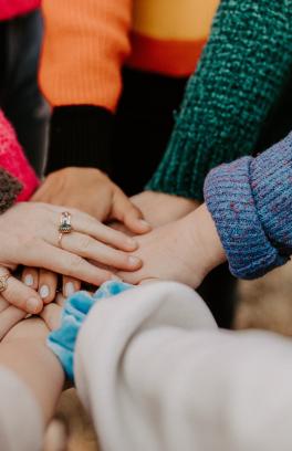 Hands in together supporting each other.