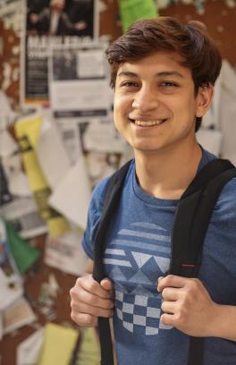 Smiling student outside of a classroom.