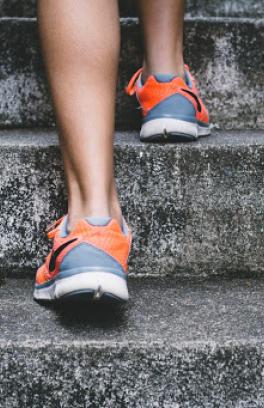 Back of somebody's athletic shoes walking up stairs.