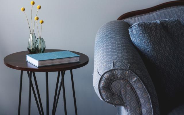 This photo is decorative. A blue chair and side table with a notebook.