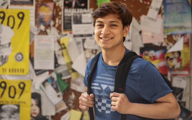 Smiling student outside of a classroom.