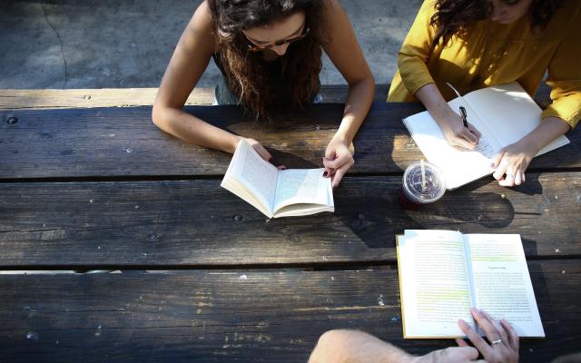 Students sitting at a table outside.