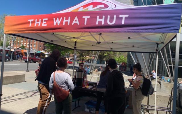 Rainbow pop up tent outside on campus representing "The Hut".