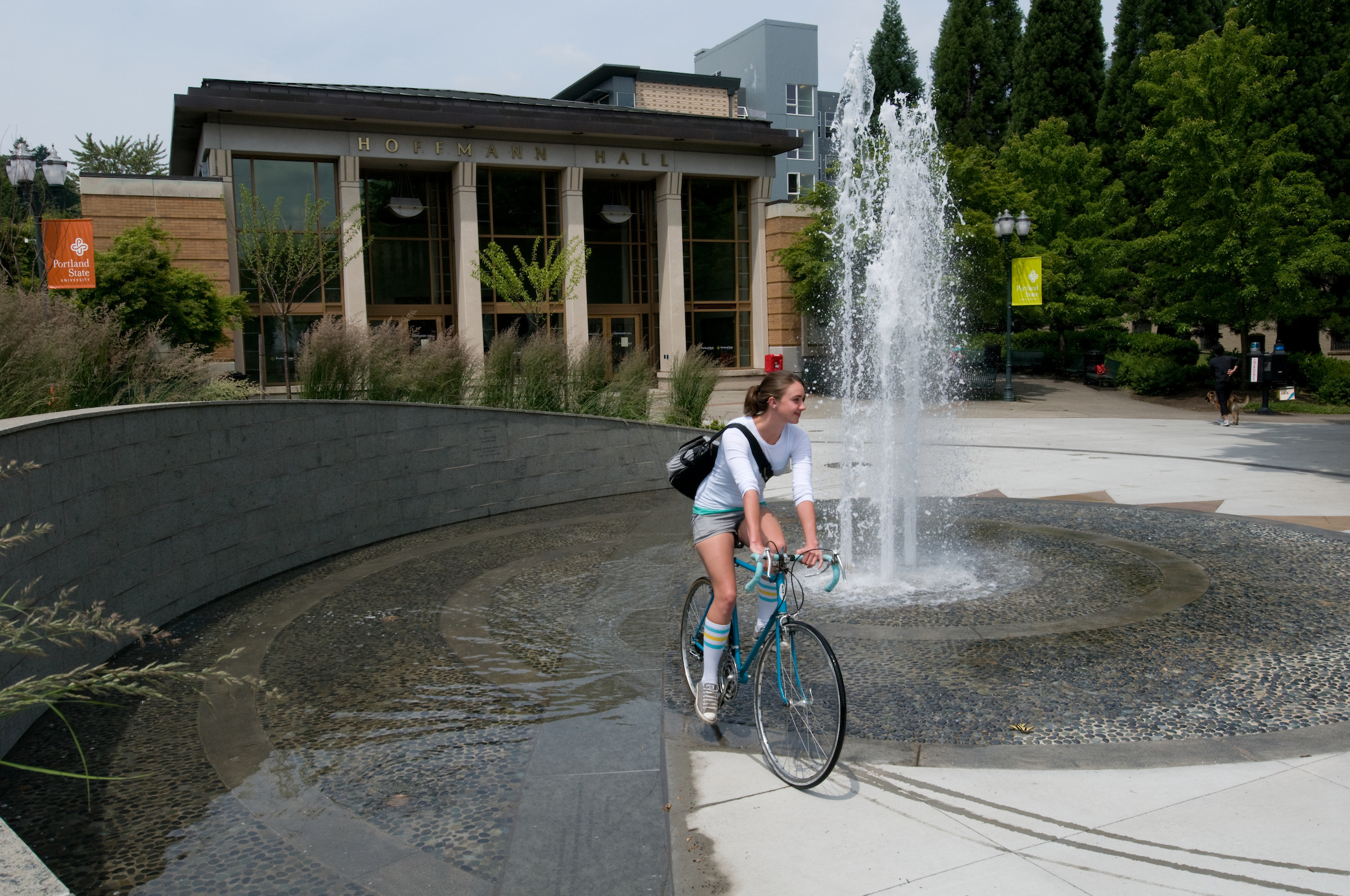 Woman on bike riding past fountain
