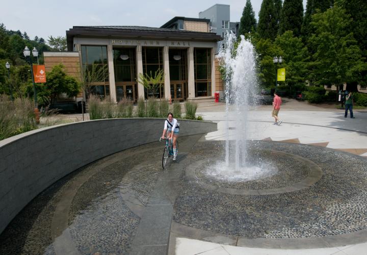 Woman on bike riding around fountain