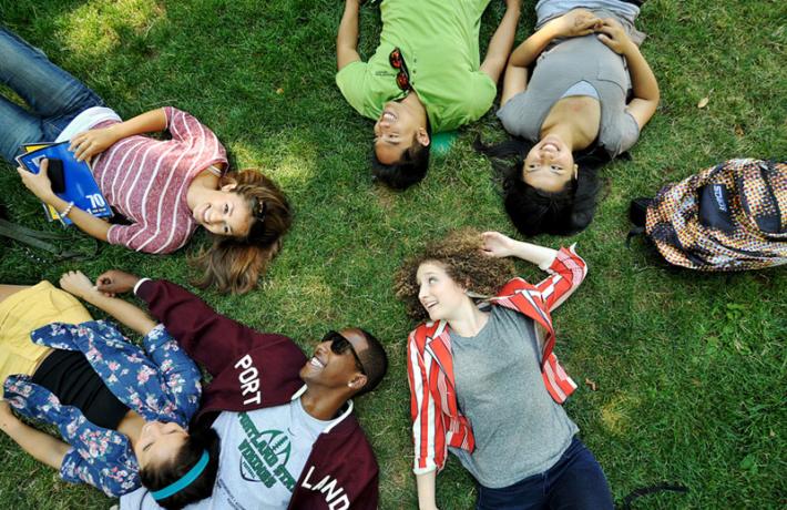 diverse students laying on grass in Park Blocks