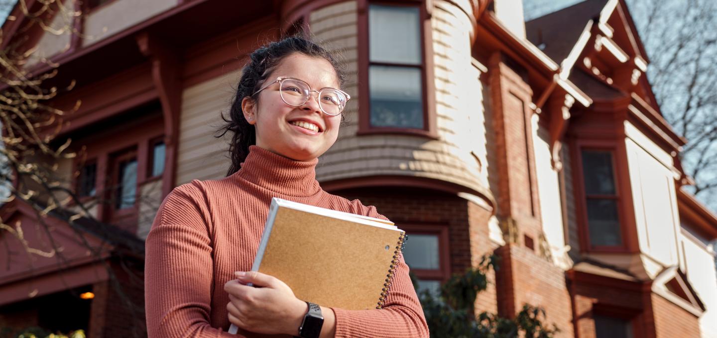 Student Standing in front of the Honors House