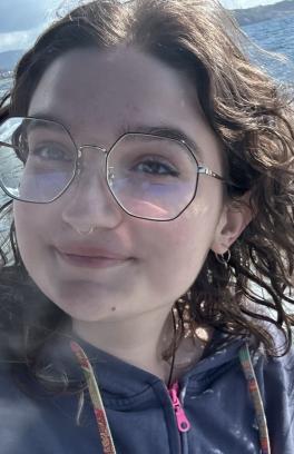 Chayse on a boat with the ocean behind