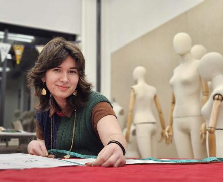 Madison Ruff, Honors student, sitting with a measuring tape and a mannequin